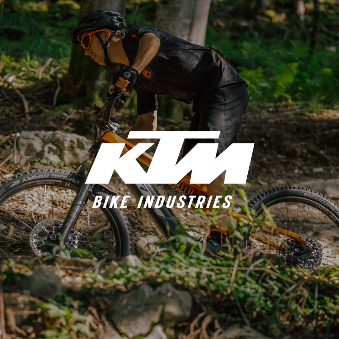 Cycliste en VTT KTM dans un sous-bois, symbole de performance autrichienne tout-terrain