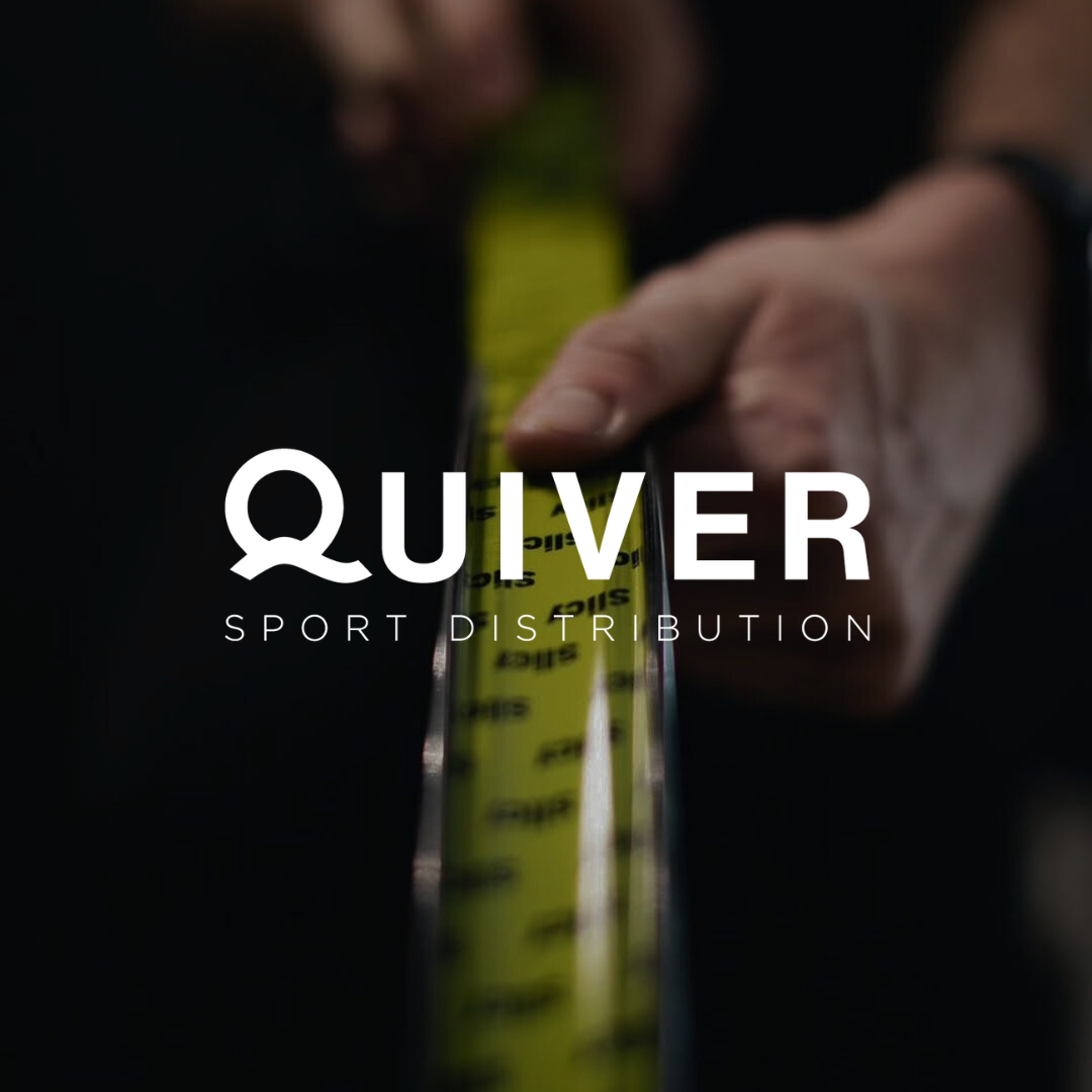 Main tenant un mètre ruban devant un atelier vélo avec le logo Quiver Sport Distribution superposé.
