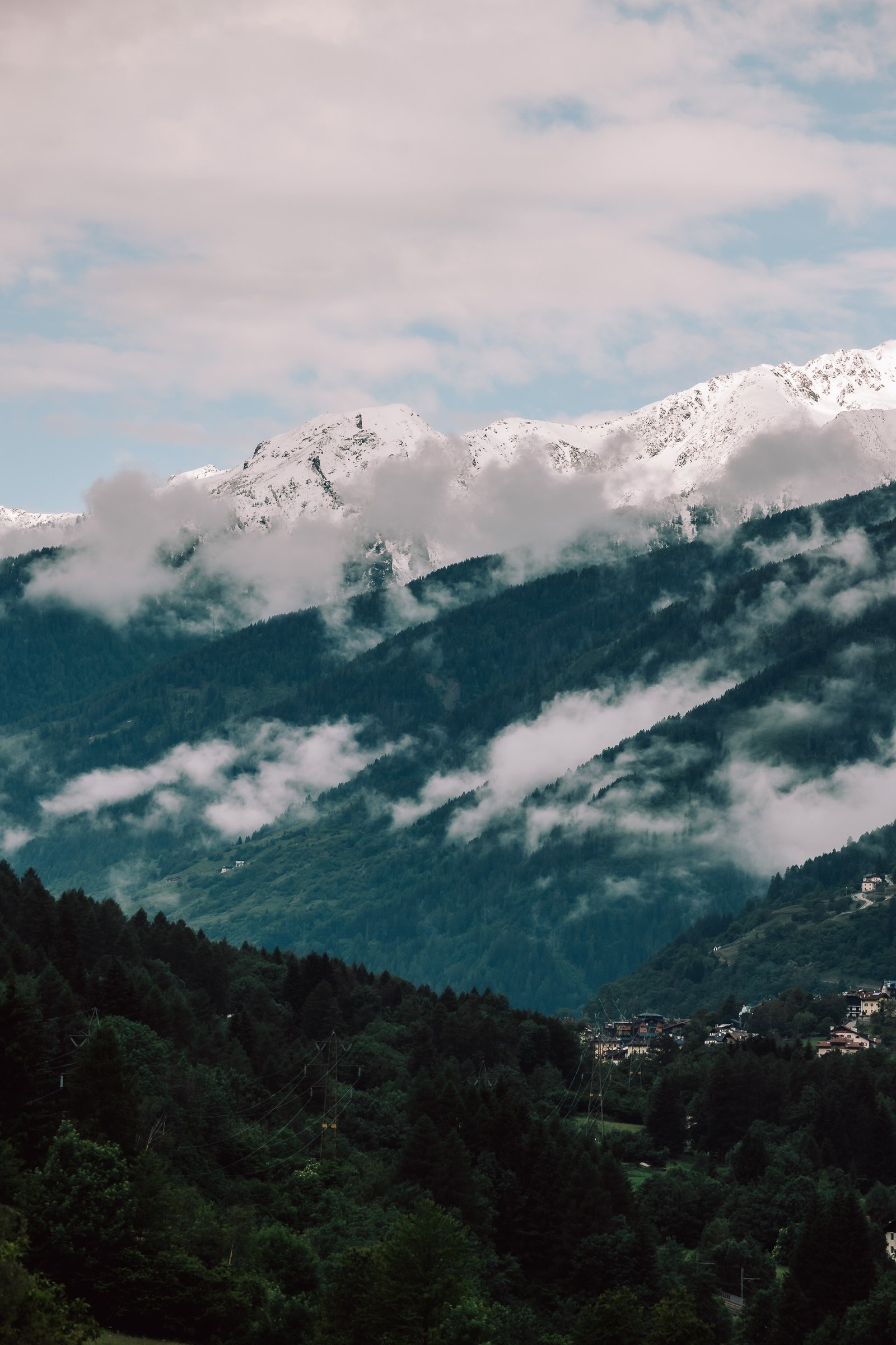 Paysage de montagne enneigée sous les nuages, évoquant la nature sauvage et les terrains exigeants où les marques d’Audace Sports prennent tout leur sens.