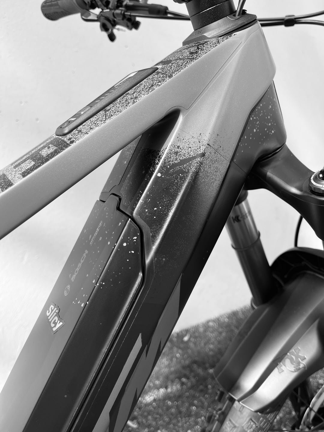 Kit de protection de cadre VTT Slicy, découpé sur mesure, appliqué sur un vélo avec finition noire effet éclaboussures.