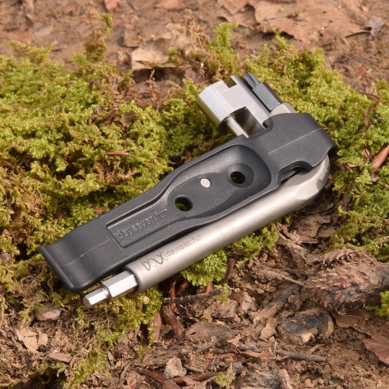 Multi-outil vélo Daysaver Essential8 avec embouts hex et Torx, posé en pleine nature sur fond de mousse.