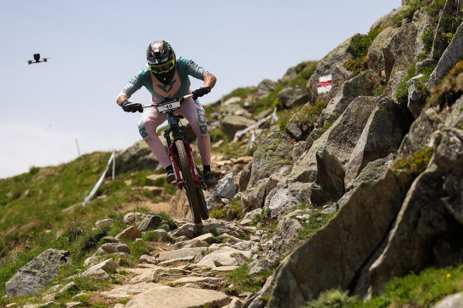 Jack Moir sur une spéciale rocheuse en compétition EWS, avec handguards Sendhit Nock V2 et grips anti-dérapants.