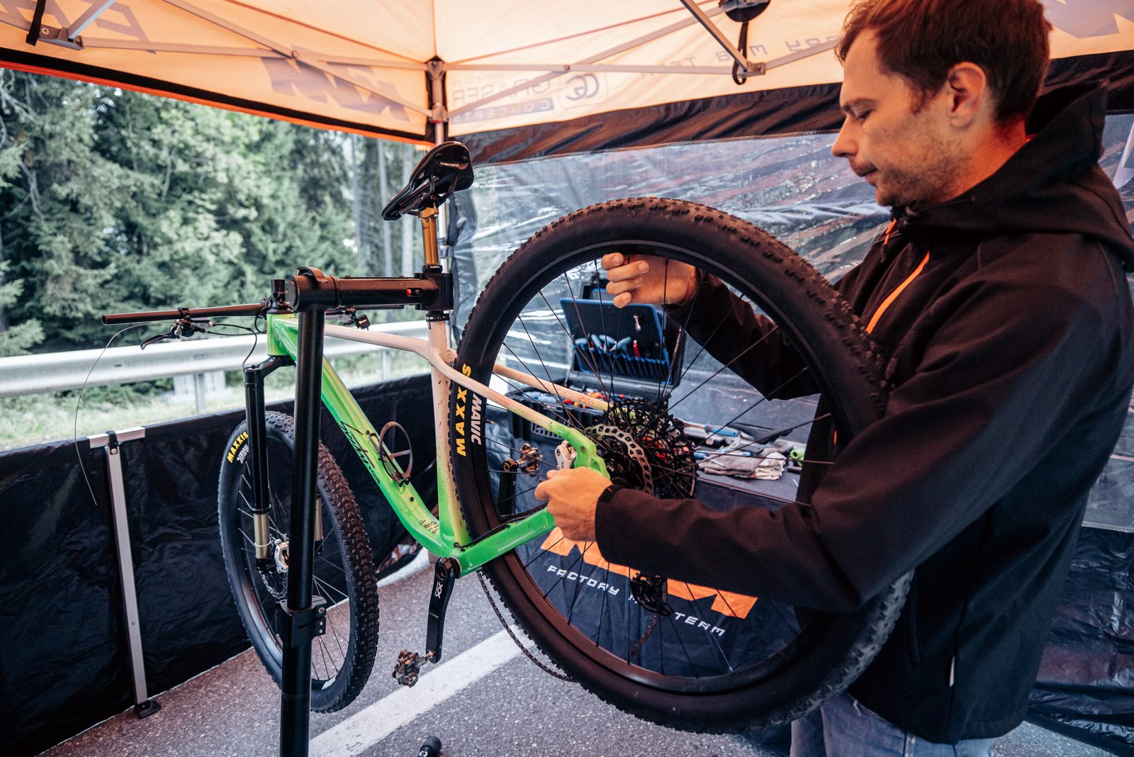 Mécanicien ajustant les réglages du KTM Sixty Four 32 pouces avant une manche de Coupe du Monde XC.