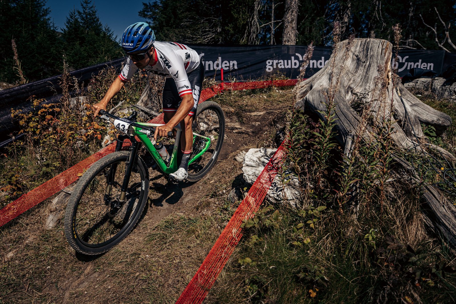 Pilote KTM engagé sur un passage technique au guidon du Sixty Four 32 pouces en Coupe du Monde XC.